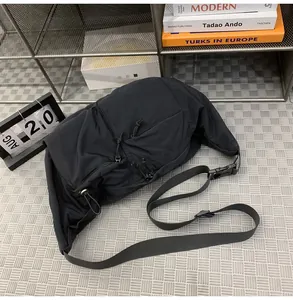Close-up of black nylon dumpling bag with adjustable strap and techwear buckle details
