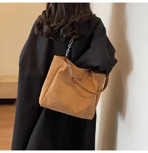 Detalle del bolso tote de pana color caramelo con textura de rayas y correa de cadena