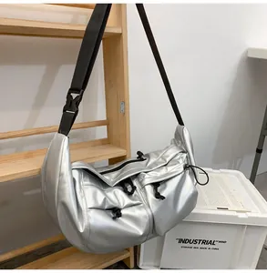 Macro detail of silver metallic nylon messenger bag with multiple drawstring pockets