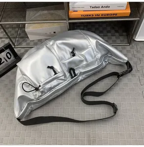 Close-up of silver crescent nylon bag with triple front drawstring pockets and black strap