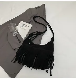 Detail van de lange franjes en de ronde touwriem van deze zwarte suède crossbodytas voor dames