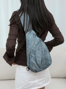 Sac bandoulière en jean bleu avec fermetures éclair vu de dos sur un mannequin