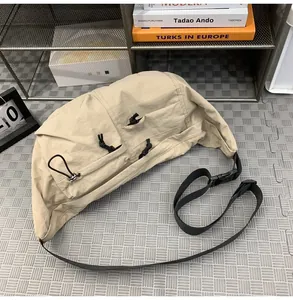 Macro detail of beige nylon crescent bag with functional drawstring utility pockets
