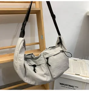 Detailed view of grey nylon crescent bag with adjustable wide strap and zipper pocket