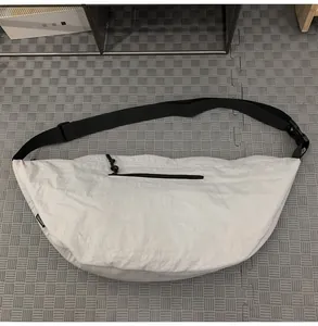 Macro detail of white nylon crescent bag showing high-quality zipper and strap texture