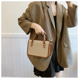 Mannequin posant avec un sac bandoulière patchwork beige caramel sur un fond de bois mural