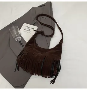 Detailopname van donkerbruine suède hobo tas met stijlvolle lange franjes eraan