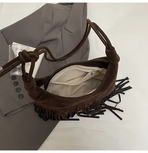 Detailopname van de bruine suède hobo tas met franjes en binnenzak met rits