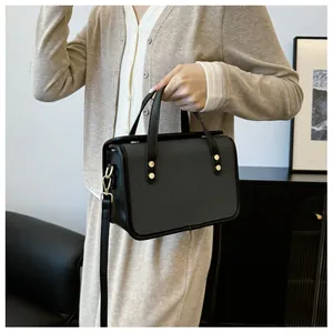 Détail d'un sac à main rétro rectangulaire en sergé gris foncé et boucles dorées