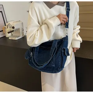 Detailed close-up of dark blue denim tote bag with adjustable strap and side pocket