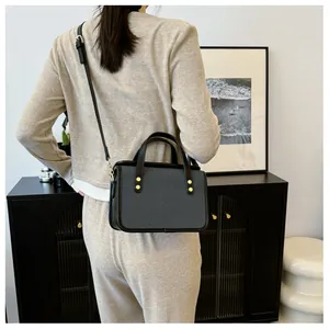 Détails du sac bandoulière gris foncé avec rivets dorés et finitions en cuir noir élégant