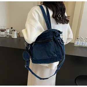 Detail of dark blue denim tote bag with multiple zipper pockets and small round coin purse