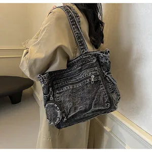 Detail of vintage washed black denim tote bag with metal zippers and mini round pouch