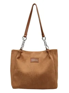 Bolso tote de pana marrón para mujer con asas de cuero y cadena sobre fondo blanco