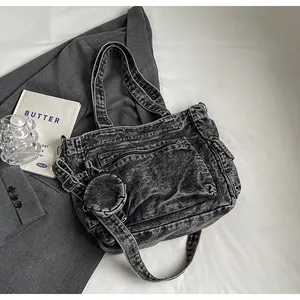 Detailed macro view of washed denim tote with front zipper pocket and round coin purse