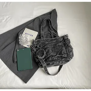 Detailed view of washed denim tote with front zipper pocket and round coin purse