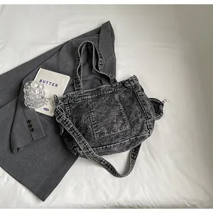 Detailed top view of a dark grey acid wash denim tote bag with a round coin purse