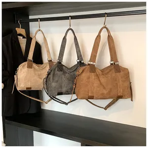 Gros plan de sacs cabas vintage en beige, gris et marron avec détails de pompons