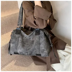 Vue détaillée du sac cabas vintage en toile gris foncé avec lanières en cuir renforcé