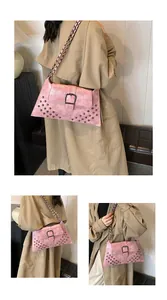 Details der rosa Vintage-Schultertasche mit Nieten und großer Schnalle am Riemen
