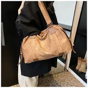 Détail du sac cabas en toile marron vintage avec bandoulière réglable et ferrures en métal