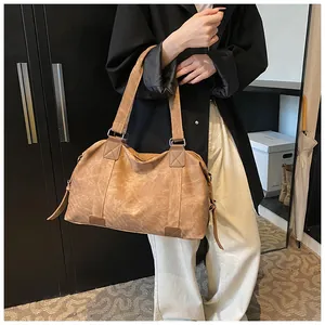 Vue détaillée d'un grand sac cabas vintage marron clair avec des poignées et coutures renforcées