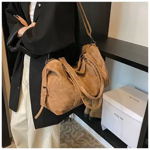 Vue détaillée du grand sac cabas vintage en cuir marron avec bandoulière et poignées réglables