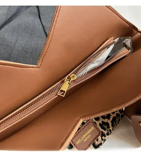 Nahaufnahme des glatten Goldreißverschlusses und Leopardenmusters auf der Tasche