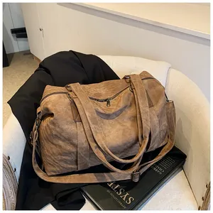 Détail du sac cabas vintage en cuir marron avec texture souple et bandoulière amovible