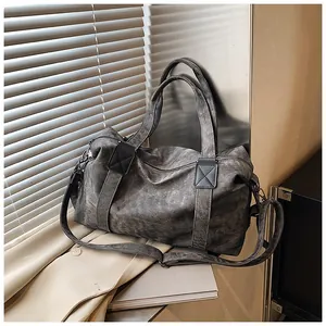 Vue détaillée de la texture rétro délavée et des poignées renforcées du sac fourre-tout