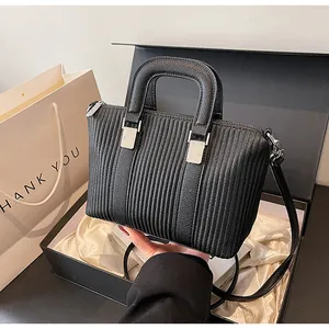Détail du sac bandoulière noir rayé dans un coffret cadeau avec garniture argentée