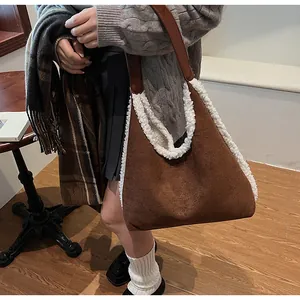 Détail du cabas en daim marron avec bordure en laine de mouton et anses en cuir