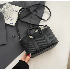 Vue détaillée de la texture matelassée verticale sur un sac à main noir pour femmes