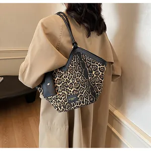 Detail der Leopard-Tragetasche mit Logo-Patch aus Leder und schmalen Trägern