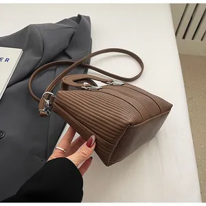 Détails de la texture rayée du sac à main marron avec ferrures métalliques argentées