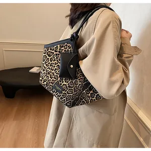 Detailansicht der Schultertasche mit Leopardenmuster, Lederbesatz und kleinem Anhänger