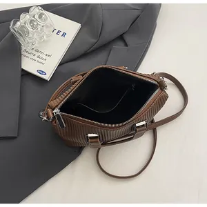 Vue intérieure du sac Boston marron rayé montrant le compartiment spacieux et la poche zippée