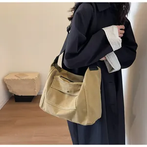 Close-up of a large mustard yellow canvas messenger bag with stylish white stitching