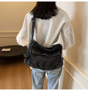 Detail showing high-capacity grey denim crossbody bag with flap pockets in retro style