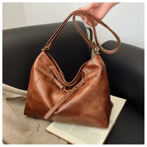 Bolso tote grande marrón oscuro con anillas metálicas y textura de cuero envejecido