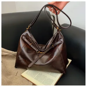 Detalle de un bolso hobo grande de cuero encerado marrón oscuro con herrajes vintage