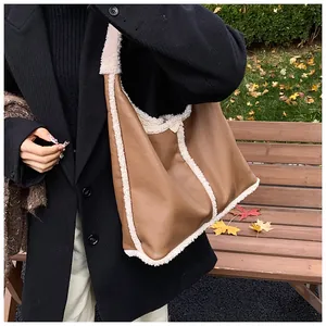 Dettaglio della borsa tote in pelle marrone con bordo in ecopelliccia bianca sulla tracolla