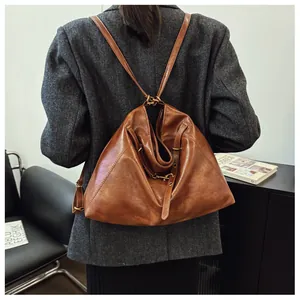 Vista trasera de la modelo con una mochila de cuero marrón vintage para el transporte diario