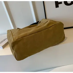 Detail view of mustard yellow canvas bag showing durable white double stitching and side construction