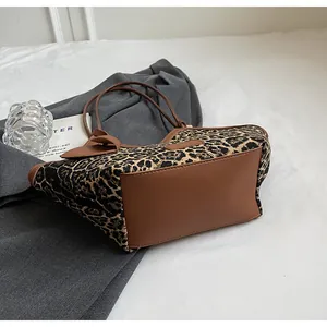 Detailansicht der Leoparden-Einkaufstasche mit braunem Lederriemen auf grauem Blazer