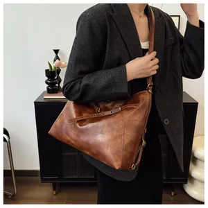 Detalle del bolso tote marrón retro con textura de cuero curtido y hebilla metálica