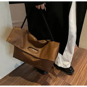 Détail du cabas en cuir plissé marron avec une bandoulière épaisse en corde torsadée noire