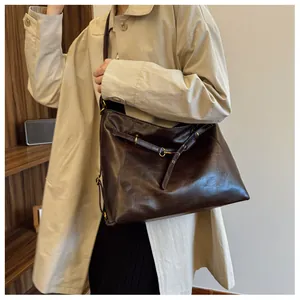 Detalle de bolso tote de cuero marrón oscuro con accesorios metálicos vintage