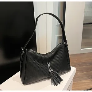 Close-up of black retro tote bag with fringe charm and premium pleated leather texture
