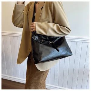 Bolso tote grande de cuero negro combinado con blazer beige y falda marrón elegante